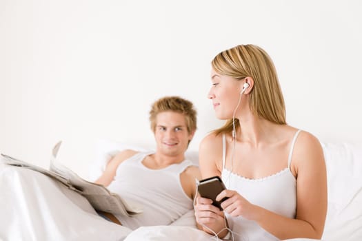 Young couple relax in bed listen to music