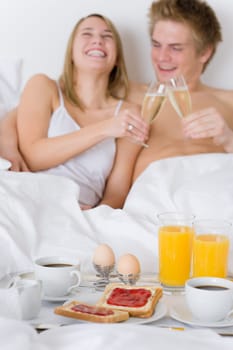 Luxury hotel honeymoon breakfast - couple in bed