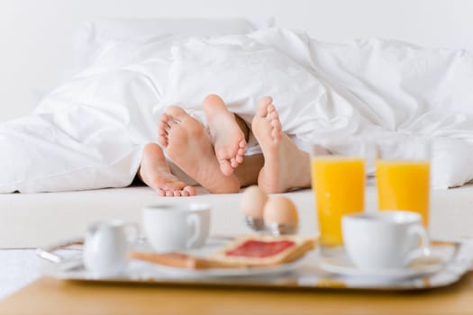 Luxury hotel honeymoon breakfast - couple in bed