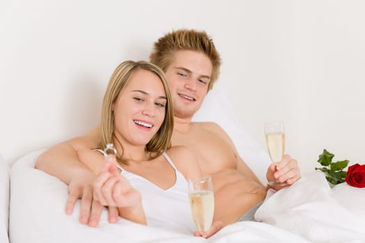 Engagement ring - couple in bed with champagne