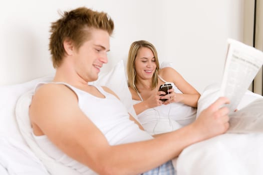 Young couple relax in bed listen to music