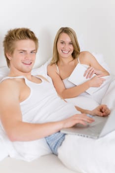 Bedroom - young couple with laptop and book