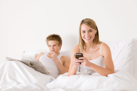 Young couple relax in bed listen to music