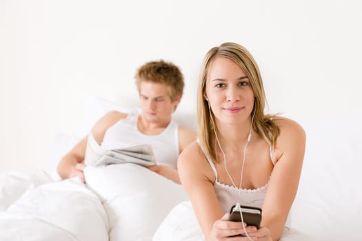 Young couple relax in bed listen to music