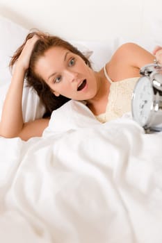 Bedroom surprise - woman with alarm clock wake up