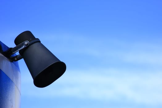 Speakers in front of a blue sky