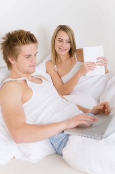 Bedroom - young couple with laptop and book