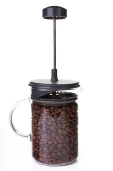 French press full of coffee beans, vertical orientation.