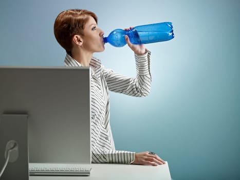 businesswoman drinking water in office