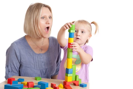 little girl and her mother playing with toy blocks