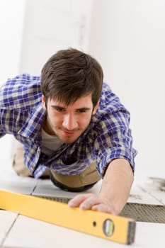 Home tile improvement - handyman with level