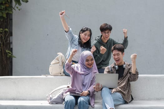 A group of multiracial students who are happy and successful in their studies. In college, laptops are used to check that academic results are on track..