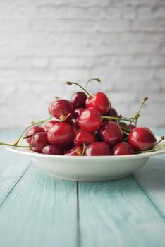 ripe fresh cherry on a white tray .