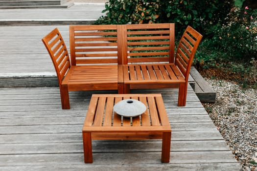 Low wooden tea table and wooden sofa in a garden
