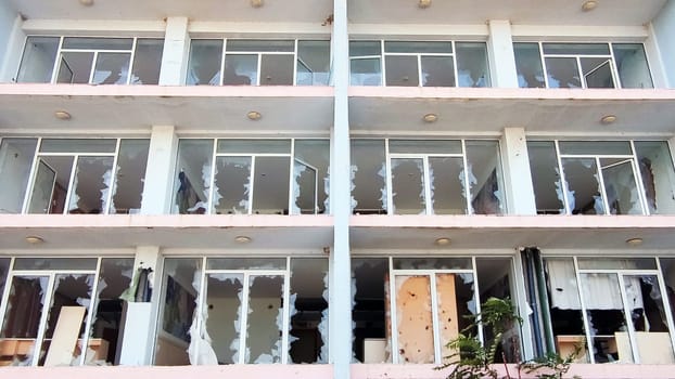 facade of an old hotel with broken windows.