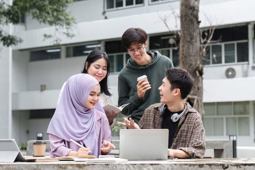 A multiracial group of students at the college, including Muslim and Asian students, sat on benches in a campus break area. Read books or study for exams together..