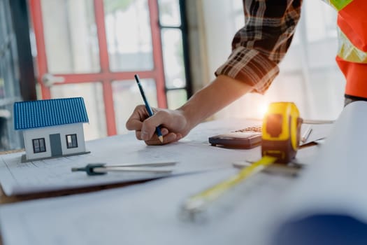 engineer brainstorming and measuring for cost estimating on blueprint and floor plan drawings about design architectural and engineering for houses and buildings.