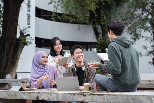 A multiracial group of students at the college, including Muslim and Asian students, sat on benches in a campus break area. Read books or study for exams together..