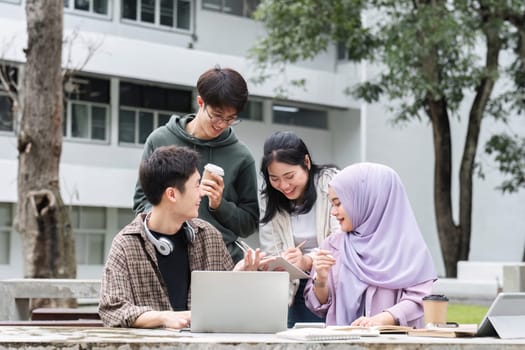 A multiracial group of students at the college, including Muslim and Asian students, sat on benches in a campus break area. Read books or study for exams together..