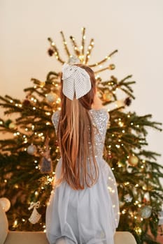 A girl decorates a Christmas tree