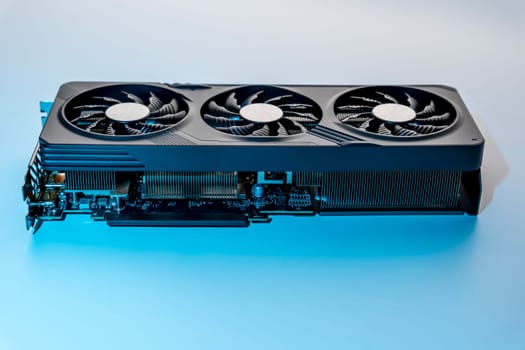 a modern powerful gaming graphics card for a computer with three fans. the concept of PC hardware. Gaming video card with neon backlight