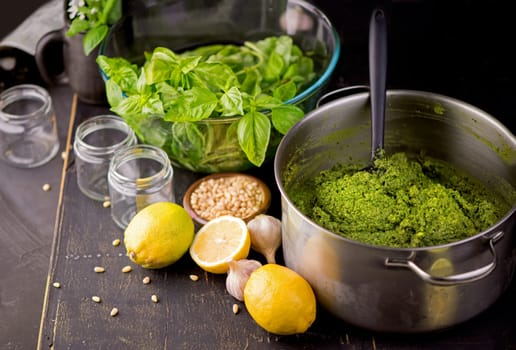 Fresh homemade pesto sauce close up and food ingredients for making pesto. Shallow depth of the field, toned and processing photo.