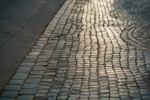 Stone pavement in perspective. Artistic texture and background. Element of the old street of the city of Lviv in Ukraine. Outdoor street design of the territory of natural stone.