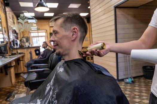 a professional hairdresser cuts a man's hair. visit to the barber shop. hair cutting for the client. creating a hairstyle in a beauty salon. Men's haircut in a barbershop.