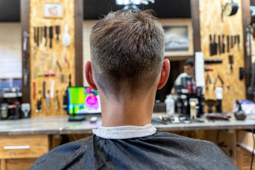 a professional hairdresser cuts a man's hair. visit to the barber shop. hair cutting for the client. creating a hairstyle in a beauty salon. Men's haircut in a barbershop.