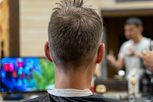 a professional hairdresser cuts a man's hair. visit to the barber shop. hair cutting for the client. creating a hairstyle in a beauty salon. Men's haircut in a barbershop.