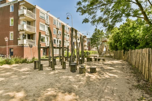 an apartment complex with trees and bushes in the fore - swayr, on a sunny day that's very clear