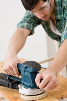Home improvement - handyman sanding wooden floor