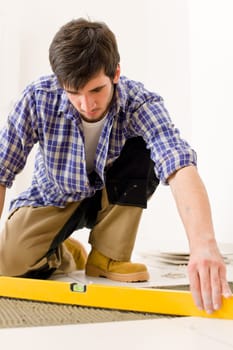 Home tile improvement - handyman with level