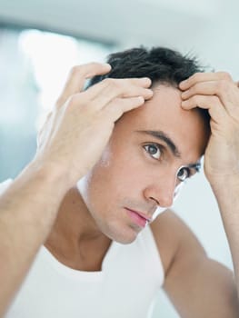 man checking receding hairline