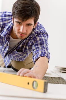 Home tile improvement - handyman with level