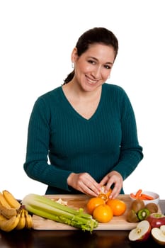 Woman peeling orange in kitchen