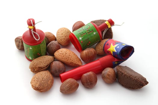 Mixed nuts with party blowers and poppers on a plain white background.