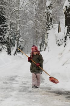 Little girl sweeping snow