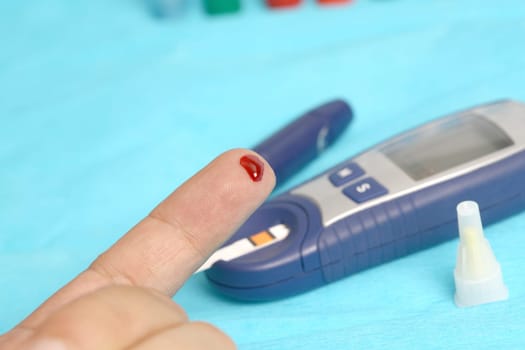 Diabetic is doing a glucose level finger blood test
