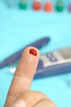 Diabetic is doing a glucose level finger blood test