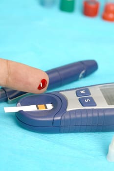 Diabetic is doing a glucose level finger blood test