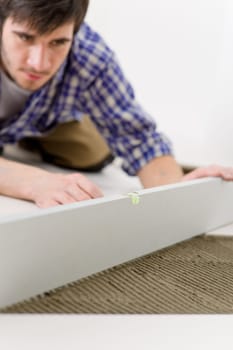 Home tile improvement - handyman with level