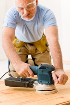 Home improvement - handyman sanding wooden floor