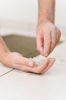 Home improvement - handyman placing tile spacer