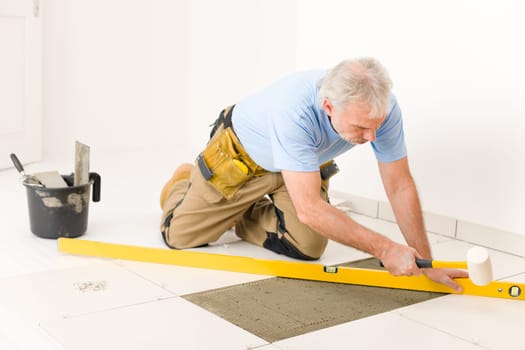 Home improvement, renovation - handyman laying ceramic tile