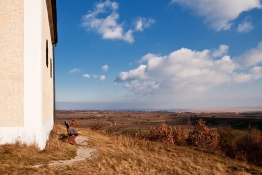 Bench in front of a chapel with a view of the plain