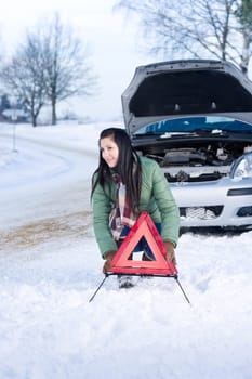 Winter car breakdown - woman warning triangle