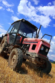 red old tractor in summer on field