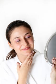 Woman in bathrobe looking in mirror