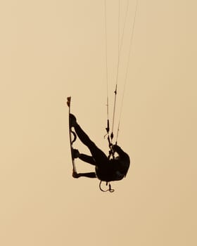 Jumping kitesurfer in backlight